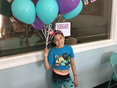 Birthday girl holding balloons